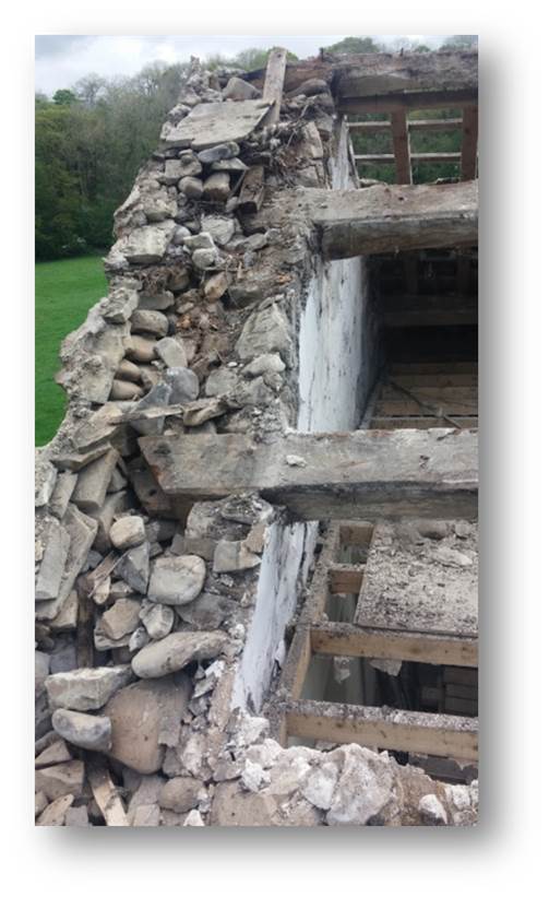 The stone walls are around two feet thick with a filling cavity between the two sides of good stone.  With the roof off, it looks a little bit fragile but feeling a little lower and the walls are solid.